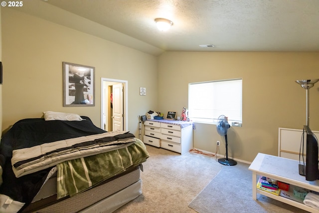 carpeted bedroom featuring baseboards, visible vents, vaulted ceiling, and a textured ceiling