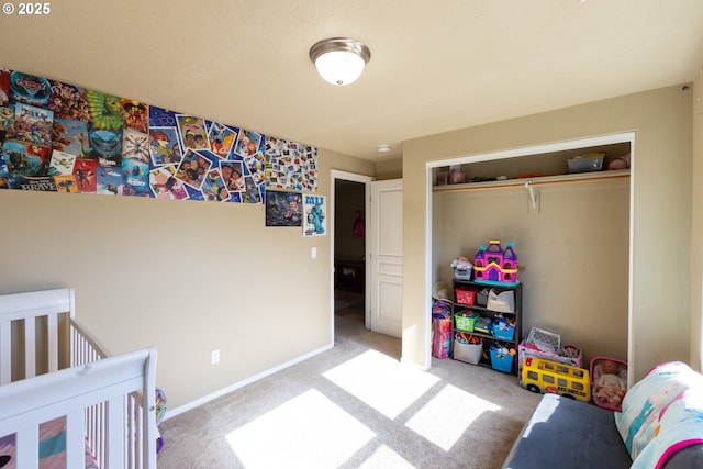 carpeted bedroom featuring a closet and baseboards