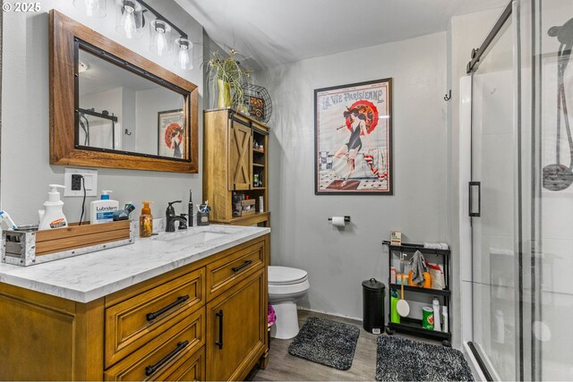 bathroom featuring vanity, an enclosed shower, and toilet