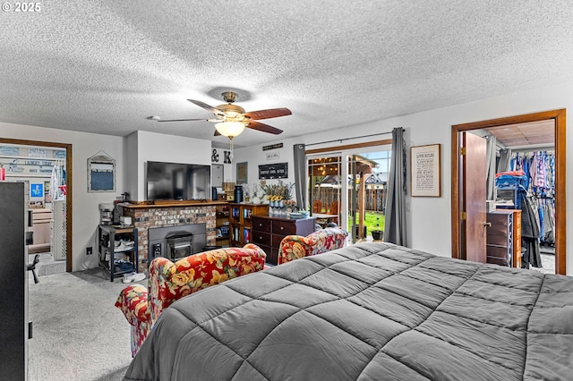 carpeted bedroom featuring access to outside, a textured ceiling, and ceiling fan