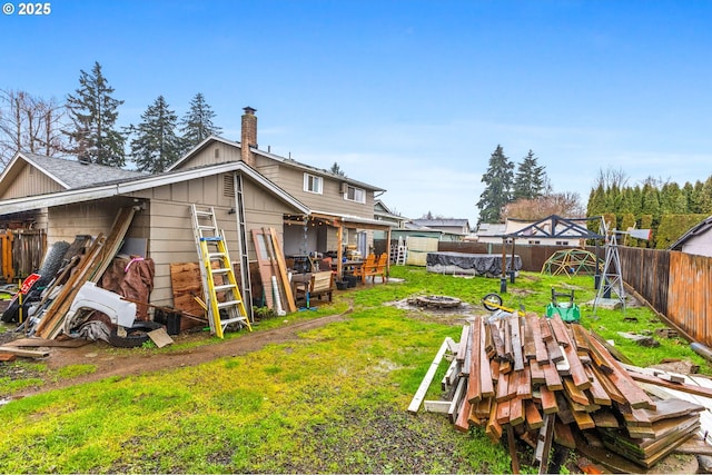 rear view of property with a yard and a fire pit