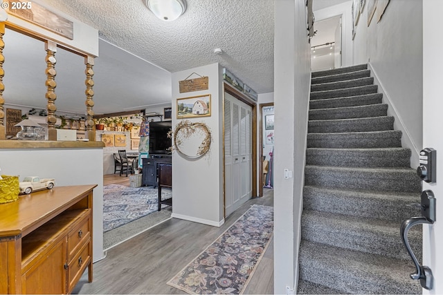 staircase featuring hardwood / wood-style flooring and a textured ceiling