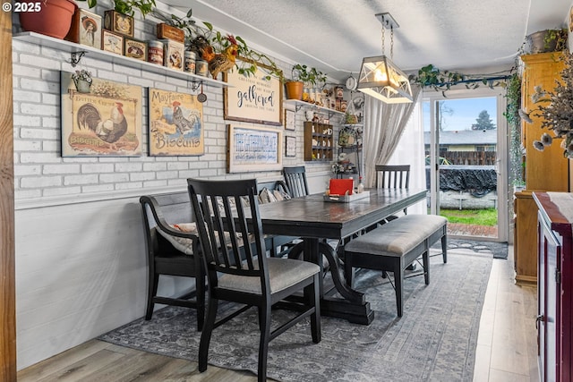 dining space featuring hardwood / wood-style floors and a textured ceiling