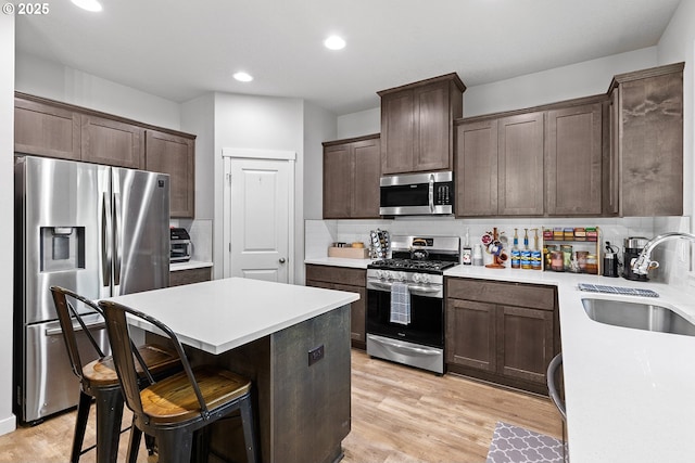 kitchen featuring tasteful backsplash, a breakfast bar, sink, and stainless steel appliances