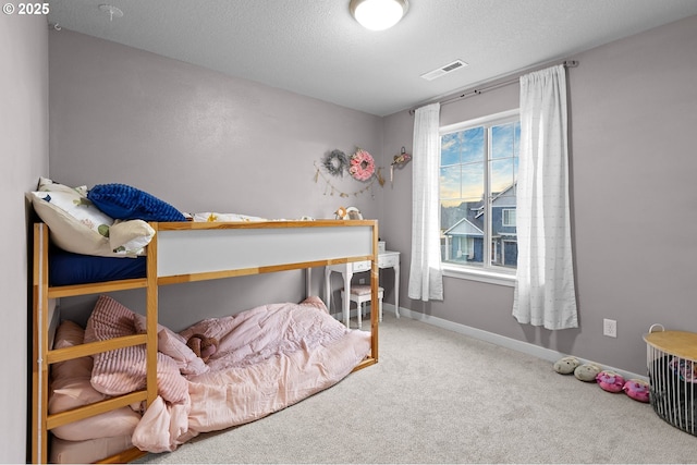 bedroom with a textured ceiling and carpet floors