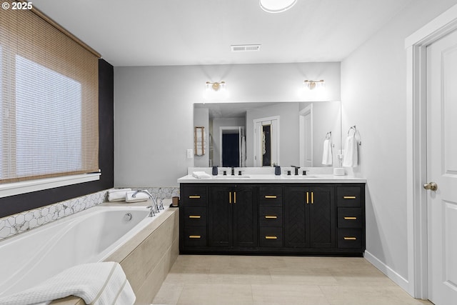 bathroom featuring vanity and a relaxing tiled tub