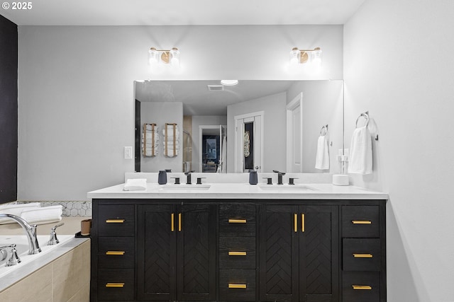 bathroom featuring vanity and tiled tub