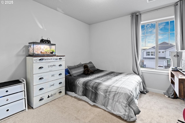 bedroom with light colored carpet and a textured ceiling