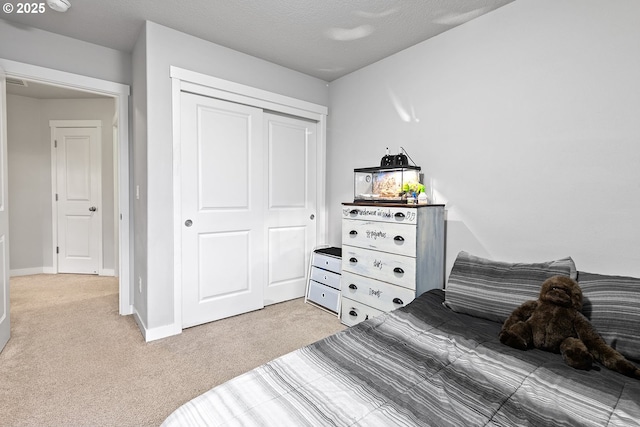 bedroom with a closet, carpet floors, and a textured ceiling