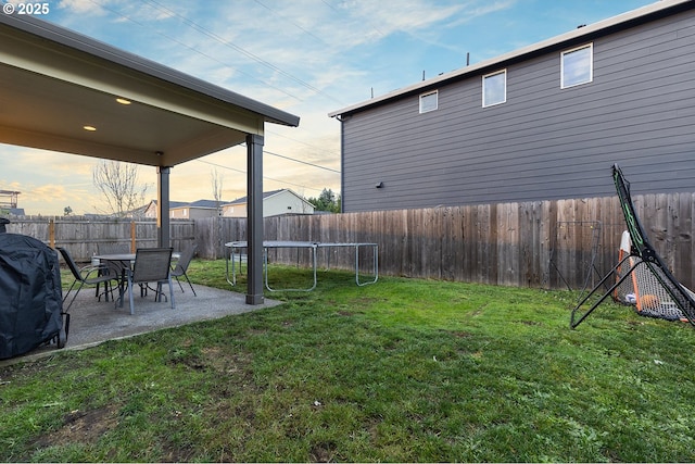 yard at dusk featuring a patio