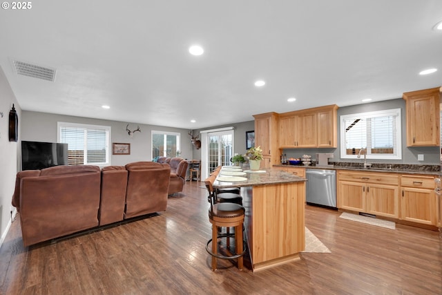 kitchen featuring light brown cabinets, wood finished floors, visible vents, open floor plan, and dishwasher