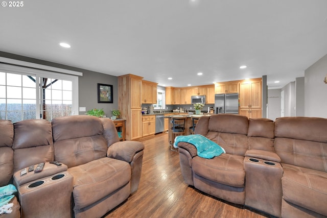 living area featuring light wood-type flooring and recessed lighting