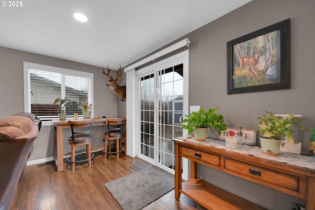 home office with baseboards, visible vents, and wood finished floors