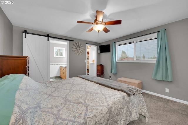 bedroom with a barn door, a ceiling fan, visible vents, baseboards, and carpet