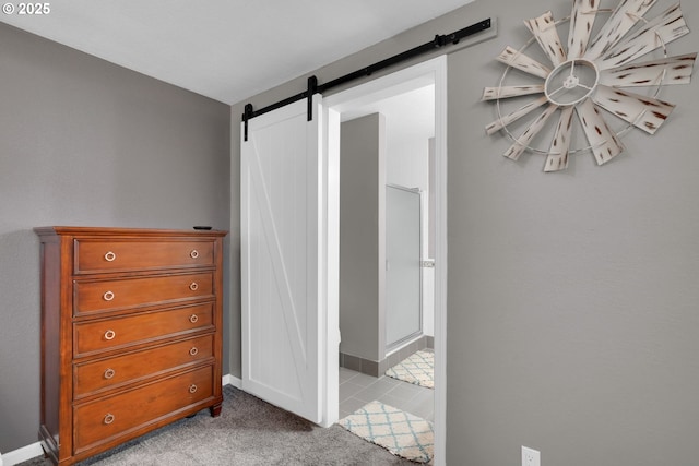 bedroom featuring carpet, a barn door, and baseboards