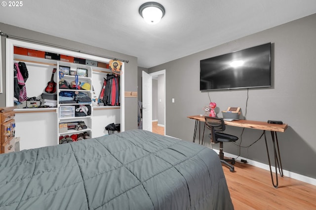 bedroom with baseboards and wood finished floors