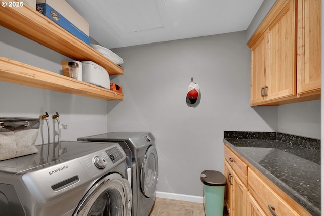 clothes washing area with independent washer and dryer, cabinet space, and baseboards