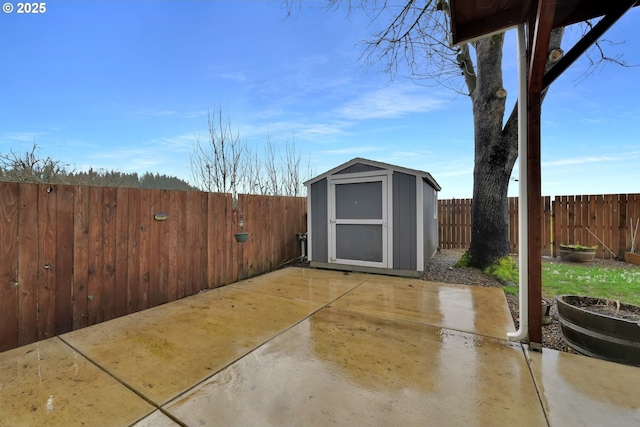 view of patio / terrace featuring a fenced backyard, a storage unit, and an outbuilding