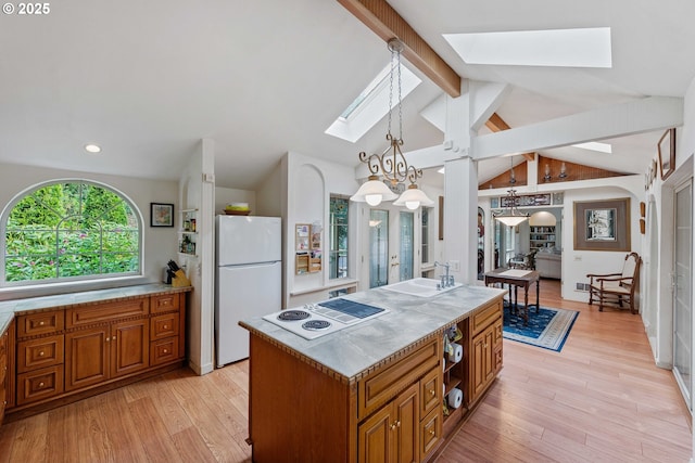 93652 E Blue Bird Ln, North Bend, OR 97459 - kitchen featuring white appliances, a skylight, brown cabinetry, light wood finished floors, and a sink