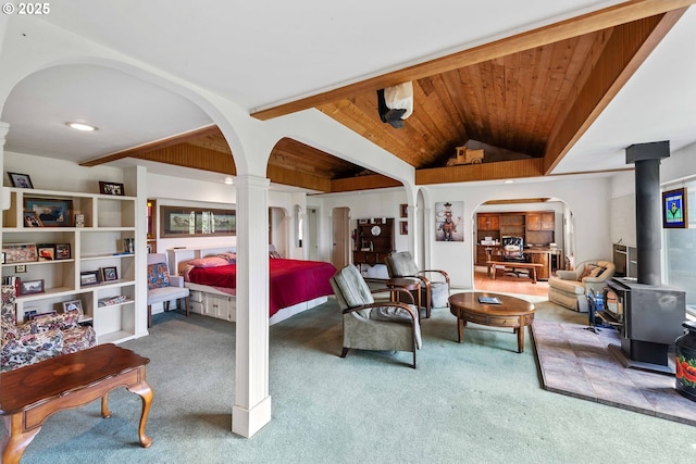 93652 E Blue Bird Ln, North Bend, OR 97459 - bedroom featuring a wood stove, carpet floors, arched walkways, wooden ceiling, and lofted ceiling