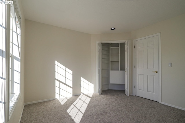 unfurnished bedroom with carpet floors, baseboards, and a closet