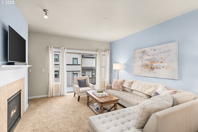 living room with baseboards, a fireplace, and light colored carpet