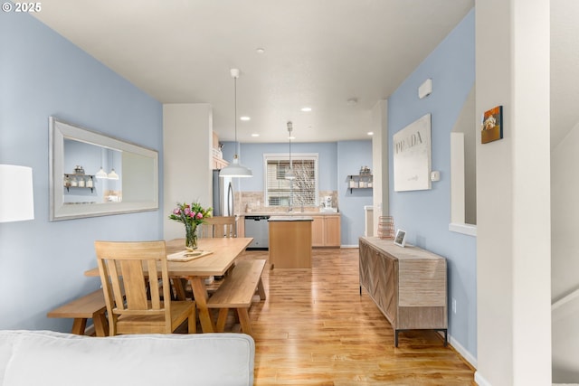 dining space with light wood finished floors, baseboards, and recessed lighting