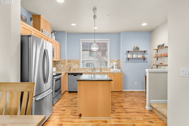 kitchen with light brown cabinets, stainless steel appliances, a sink, and decorative backsplash