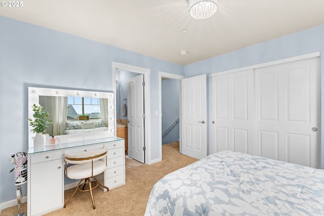 bedroom with baseboards, a closet, and light colored carpet