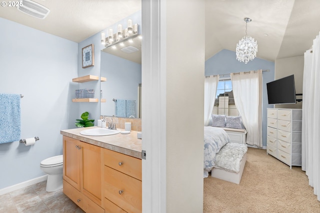 ensuite bathroom with a notable chandelier, lofted ceiling, toilet, vanity, and ensuite bath