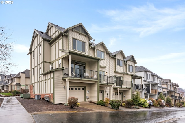 view of property with a garage, a residential view, and central AC