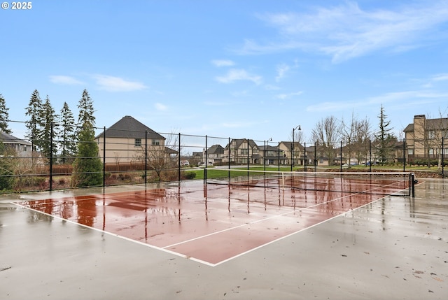 view of community featuring a tennis court, a residential view, and fence