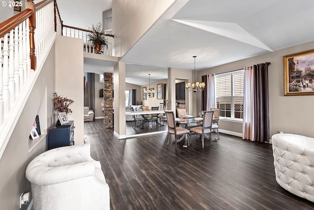 dining room featuring an inviting chandelier, dark hardwood / wood-style flooring, vaulted ceiling, and ornate columns