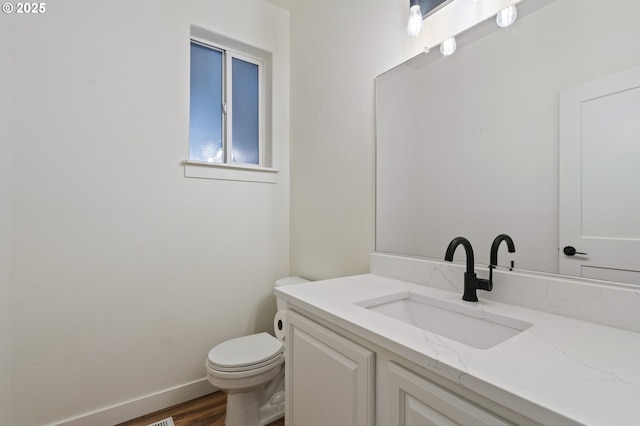 bathroom featuring vanity, wood-type flooring, and toilet