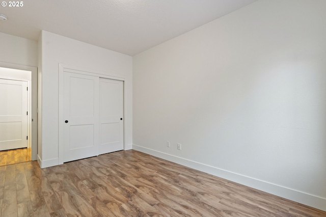 unfurnished bedroom with a closet and light hardwood / wood-style flooring