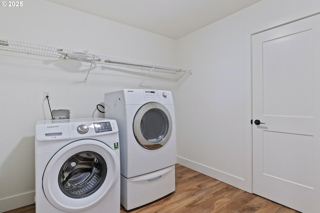 laundry area with hardwood / wood-style flooring and washer and dryer