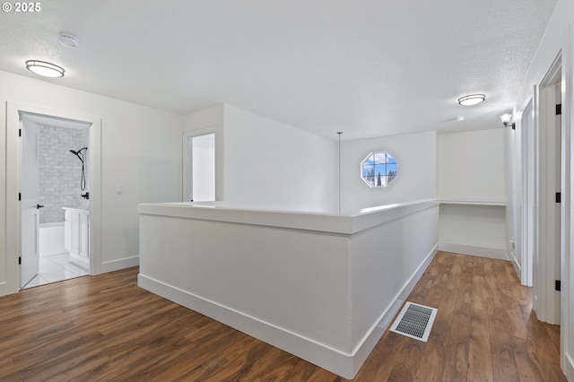 hallway with hardwood / wood-style flooring and a textured ceiling