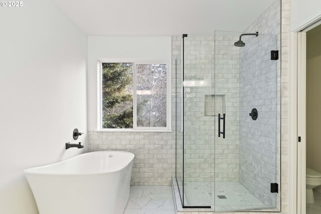 bathroom featuring shower with separate bathtub and toilet