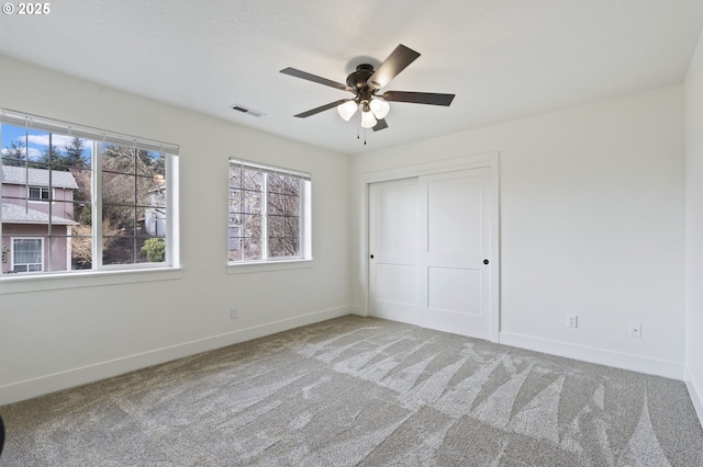 unfurnished bedroom with carpet flooring, ceiling fan, and a closet