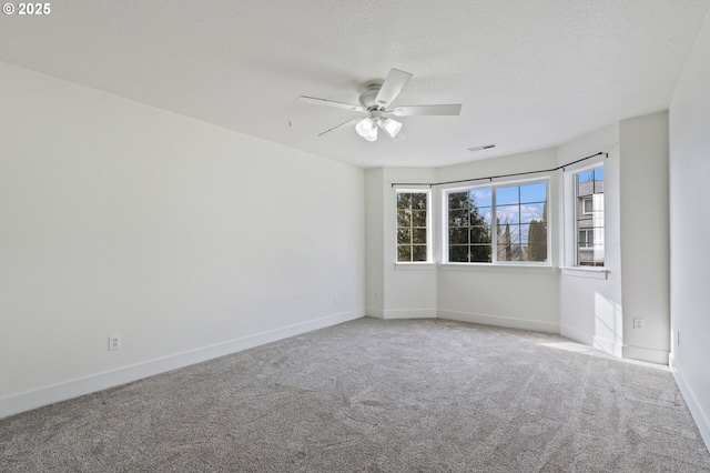 empty room featuring ceiling fan, carpet floors, and a textured ceiling