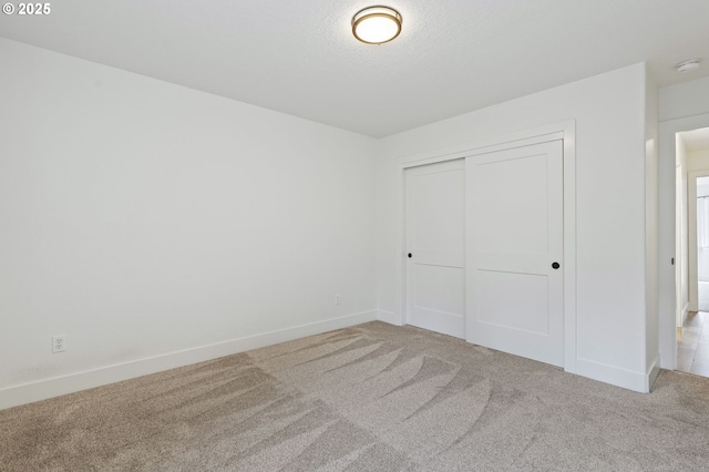 unfurnished bedroom featuring a closet, a textured ceiling, and carpet