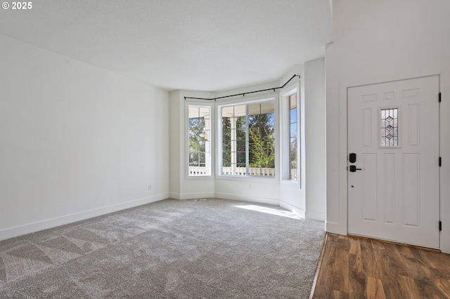 carpeted entryway featuring a textured ceiling