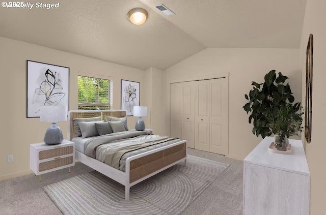 608 NE Adwick Dr, Beaverton, OR 97006 - bedroom with light carpet, vaulted ceiling, a closet, and a textured ceiling