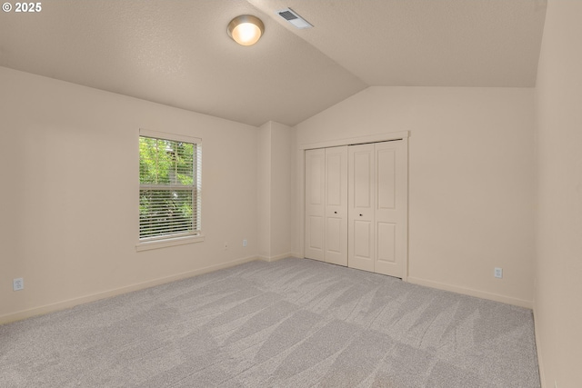 608 NE Adwick Dr, Beaverton, OR 97006 - unfurnished bedroom with lofted ceiling, carpet, a closet, and a textured ceiling