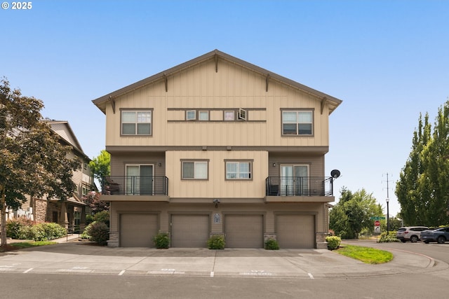 608 NE Adwick Dr, Beaverton, OR 97006 - view of front of home with a balcony, an attached garage, stone siding, board and batten siding, and driveway