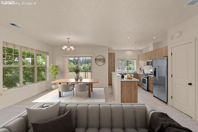 608 NE Adwick Dr, Beaverton, OR 97006 - living area featuring a chandelier, plenty of natural light, a textured ceiling, and recessed lighting