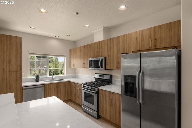 608 NE Adwick Dr, Beaverton, OR 97006 - kitchen featuring appliances with stainless steel finishes, recessed lighting, light countertops, a textured ceiling, and modern cabinets