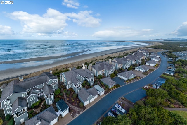 birds eye view of property with a water view and a beach view