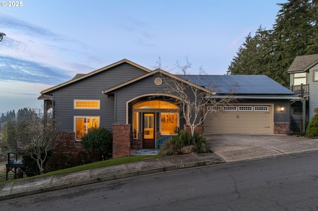 view of front of home with a garage and solar panels