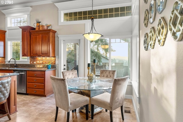 tiled dining area featuring a high ceiling, a wealth of natural light, and sink